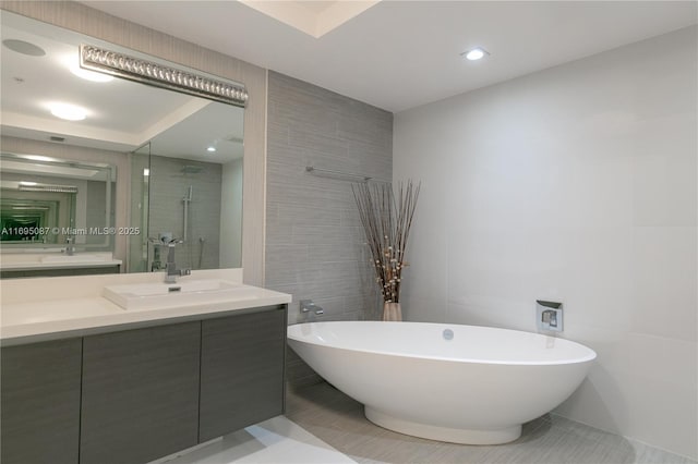 full bath featuring a soaking tub, a shower stall, tile walls, and vanity