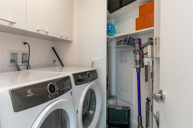 laundry room with independent washer and dryer and cabinet space