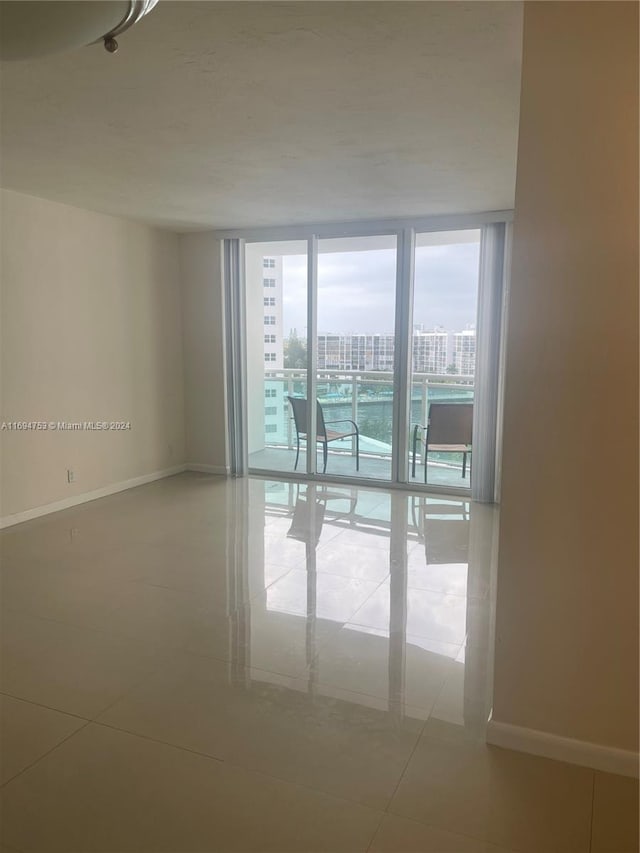 tiled spare room with floor to ceiling windows