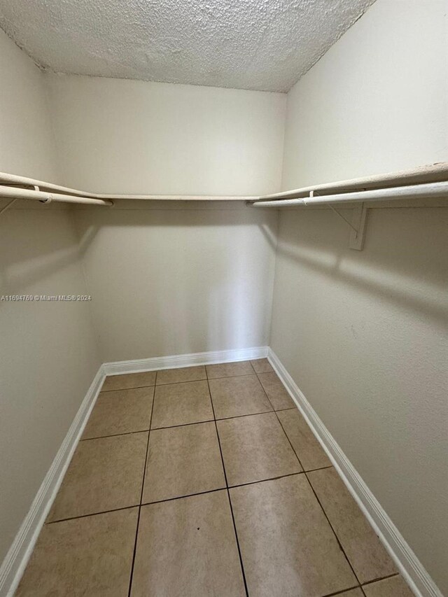 walk in closet with tile patterned floors