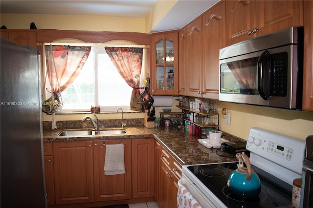 kitchen with sink, dark stone counters, and appliances with stainless steel finishes