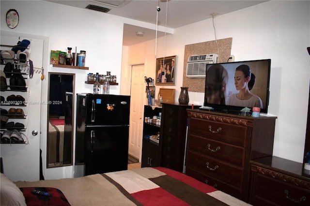 bedroom featuring a wall mounted air conditioner and black fridge