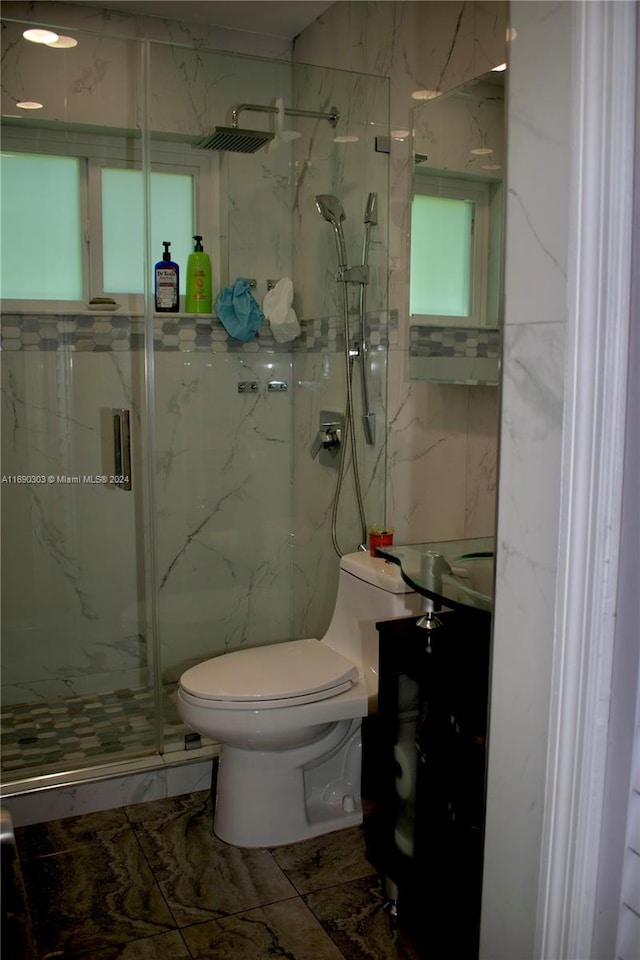 bathroom with vanity, toilet, and a shower with door