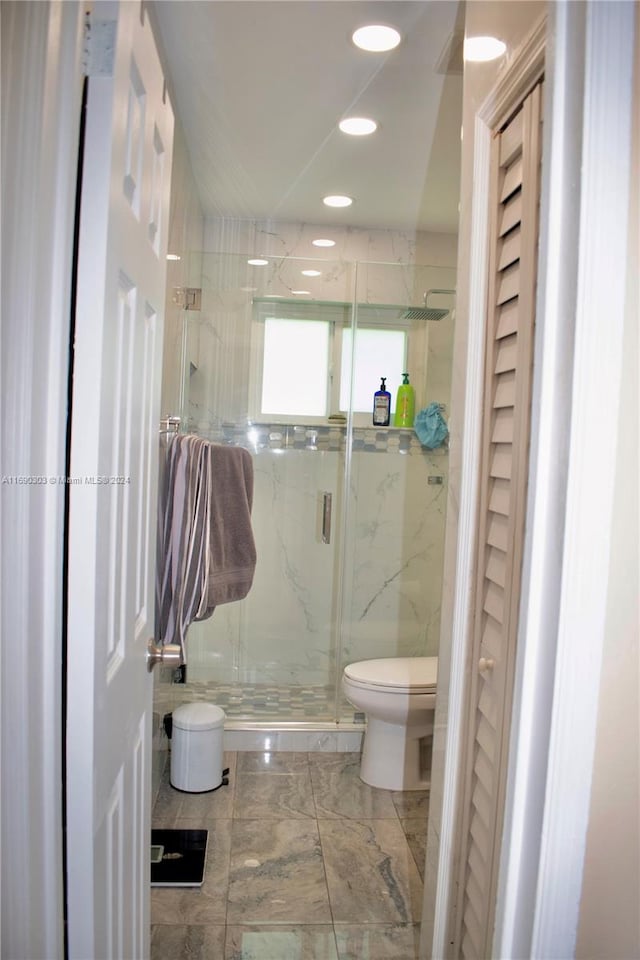 bathroom featuring toilet, tile walls, and walk in shower