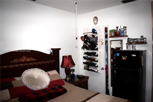 bedroom featuring black refrigerator