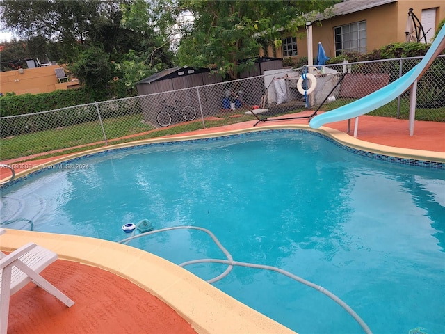 view of swimming pool with a water slide