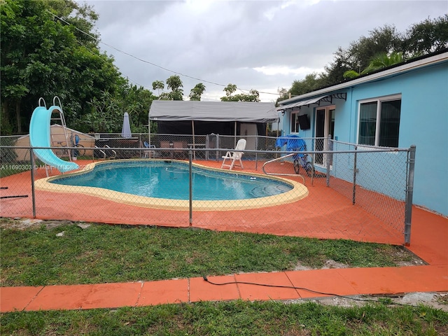 view of pool with a patio area and a water slide