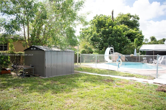 view of yard with a fenced in pool and a storage shed