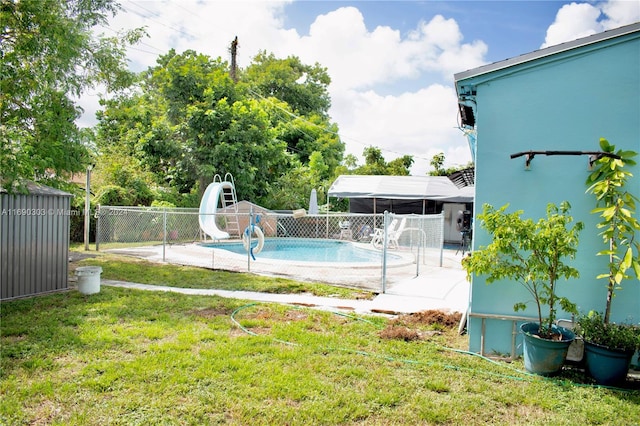 view of swimming pool with a lawn and a water slide