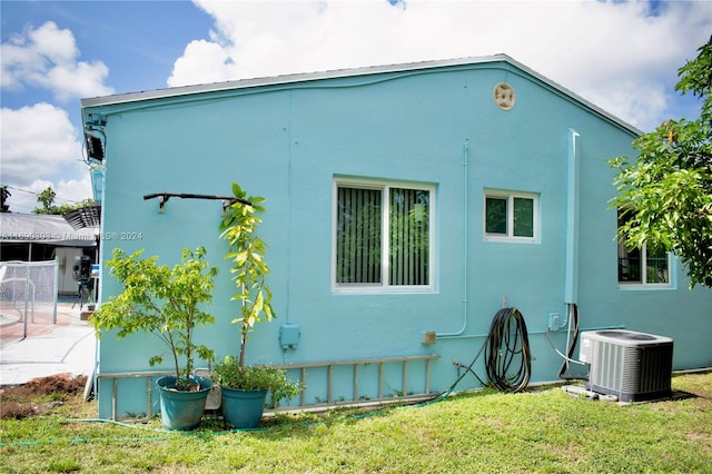 view of property exterior with a lawn and cooling unit