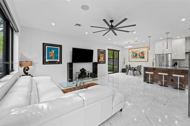 living room with a ceiling fan, recessed lighting, marble finish floor, and visible vents