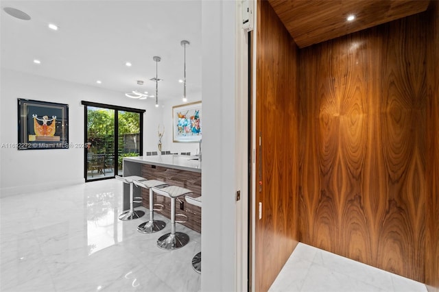 interior space with marble finish floor, elevator, and recessed lighting