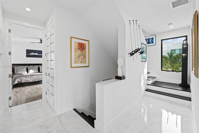 corridor with marble finish floor, baseboards, stairs, and visible vents