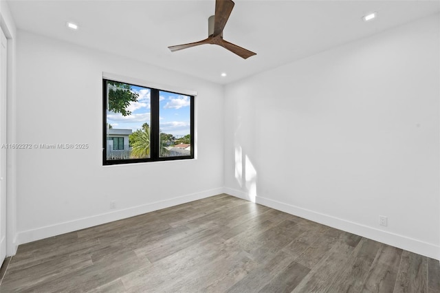 spare room with ceiling fan, recessed lighting, wood finished floors, and baseboards