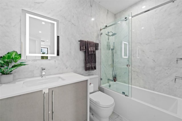 full bath featuring bath / shower combo with glass door, vanity, toilet, and tile walls