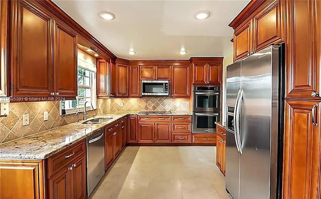 kitchen with light stone counters, sink, stainless steel appliances, and tasteful backsplash