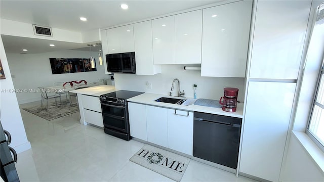 kitchen featuring black appliances, white cabinetry, and sink