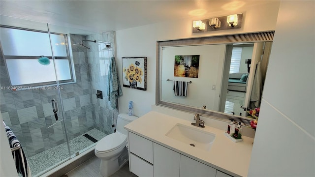 bathroom featuring a shower with door, vanity, and toilet