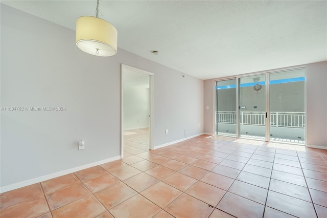 unfurnished room featuring floor to ceiling windows and light tile patterned floors