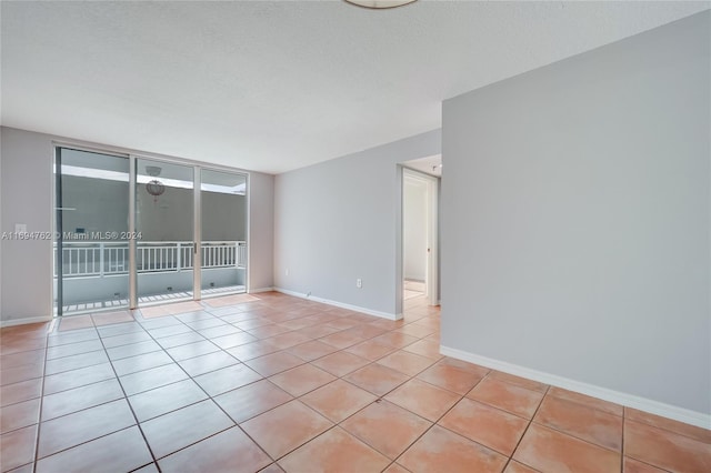 tiled spare room featuring a textured ceiling