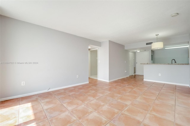 unfurnished living room with light tile patterned floors and sink