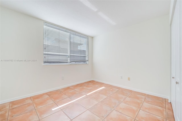 spare room featuring light tile patterned flooring