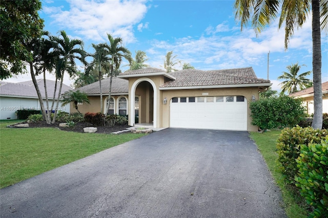 mediterranean / spanish home with a garage and a front lawn