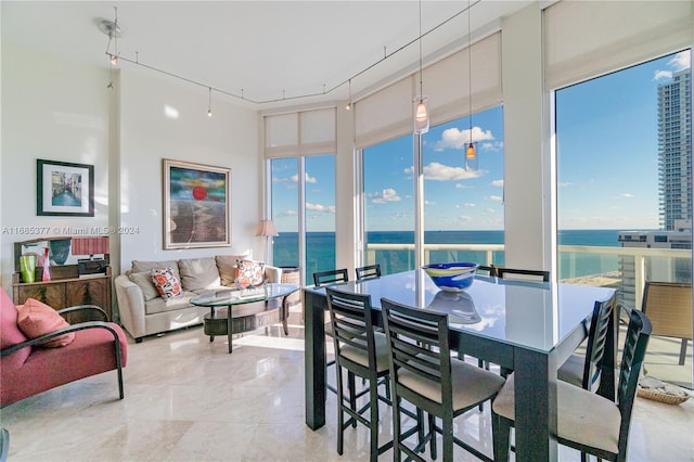 sunroom / solarium with a water view and rail lighting