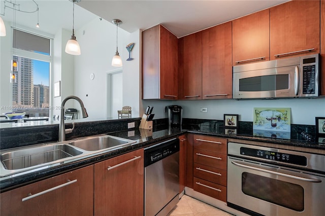 kitchen featuring sink, decorative light fixtures, dark stone countertops, and stainless steel appliances