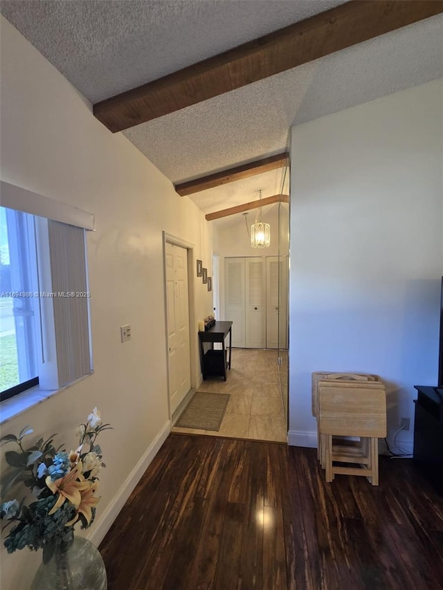 hallway featuring vaulted ceiling with beams, hardwood / wood-style floors, and a textured ceiling