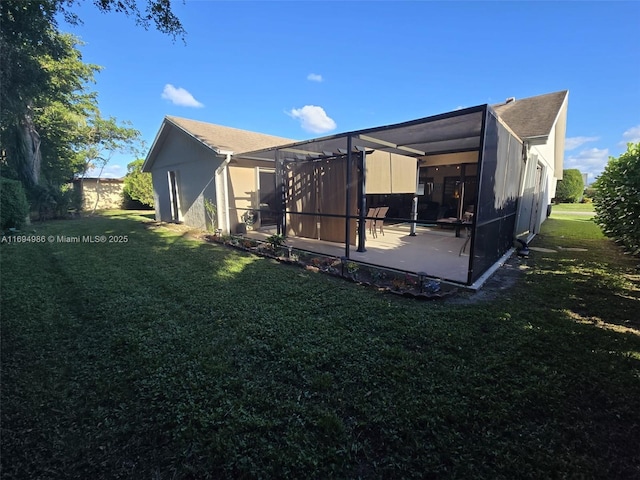 back of property with a patio, a lanai, and a lawn