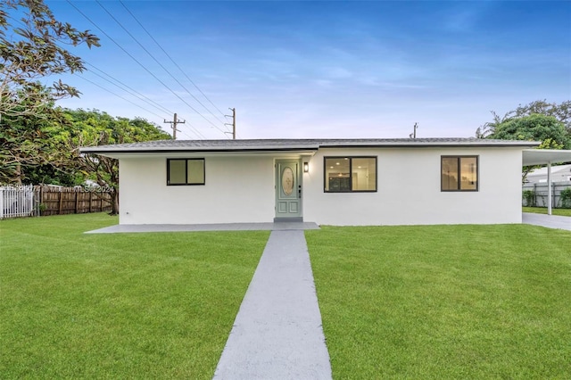 ranch-style house featuring a carport and a front lawn