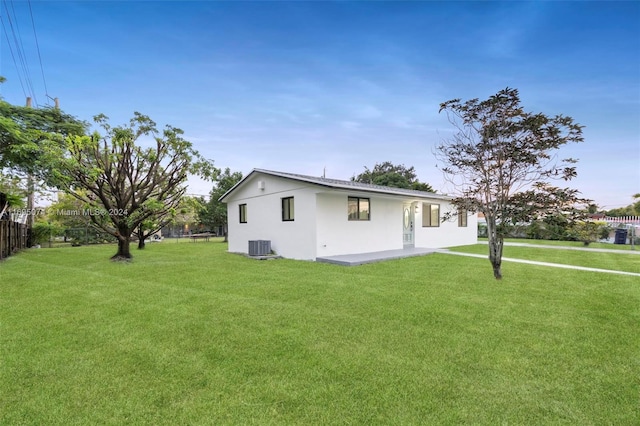 view of side of property featuring a lawn and central AC unit