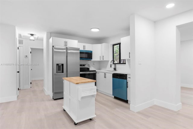 kitchen with a kitchen island, light wood-type flooring, white cabinetry, and appliances with stainless steel finishes