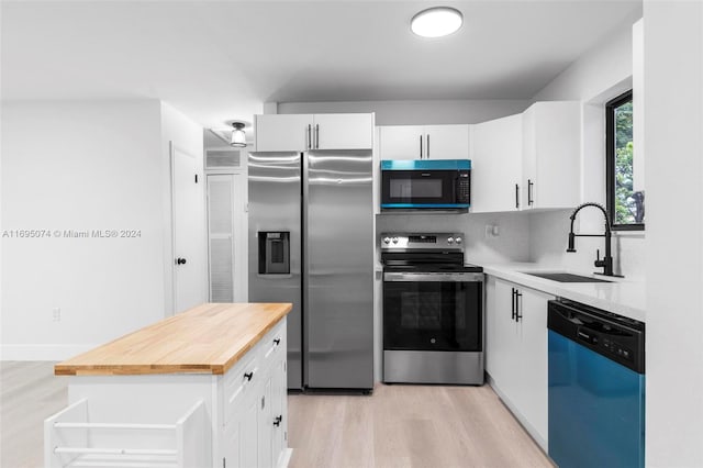 kitchen featuring butcher block counters, white cabinetry, sink, and appliances with stainless steel finishes