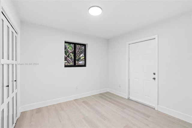 unfurnished bedroom with light wood-type flooring and a closet