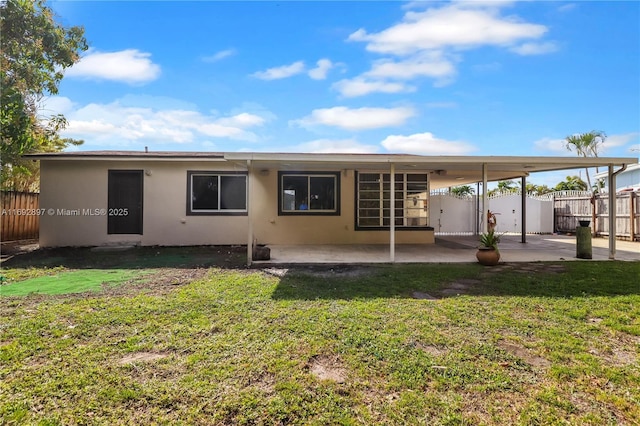 back of house featuring a yard and a patio area