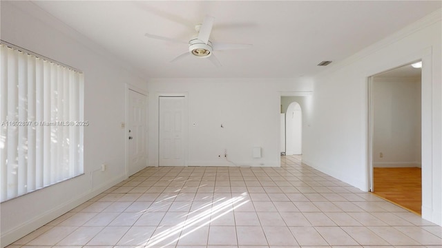 tiled spare room with ceiling fan and ornamental molding