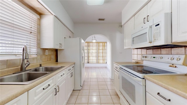 kitchen featuring white cabinetry, sink, backsplash, white appliances, and light tile patterned flooring