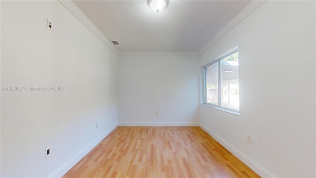 empty room featuring crown molding and wood-type flooring