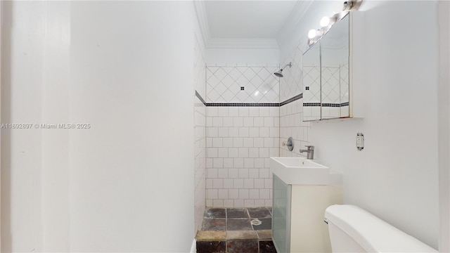 bathroom with tiled shower, toilet, vanity, and ornamental molding