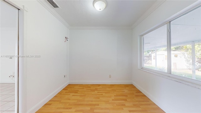 spare room with crown molding and light hardwood / wood-style floors