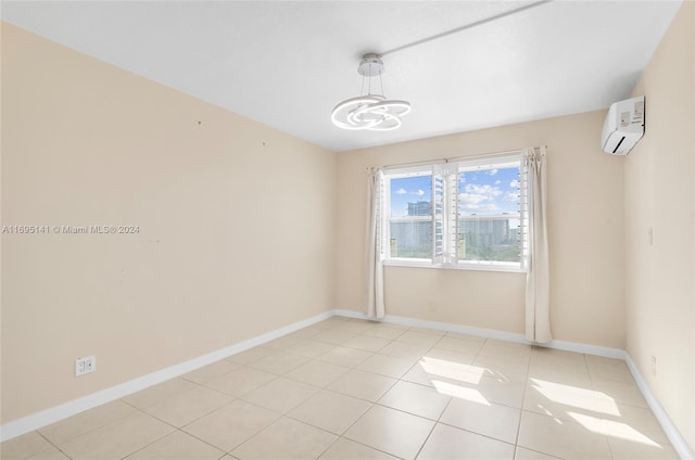 tiled spare room featuring a wall mounted air conditioner and an inviting chandelier