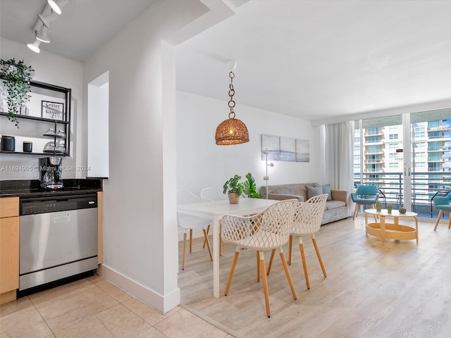 dining space featuring light wood-type flooring and rail lighting