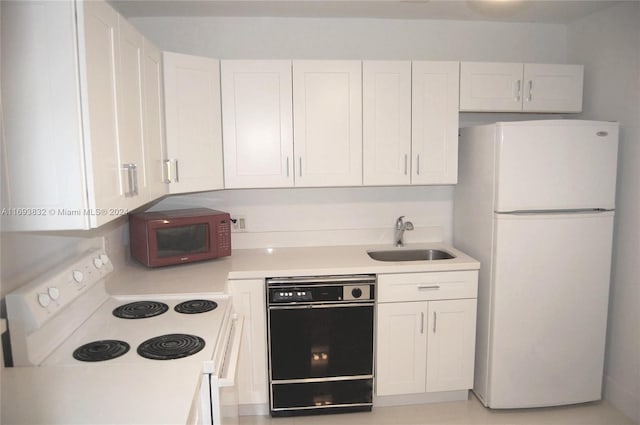 kitchen with black appliances, white cabinetry, and sink