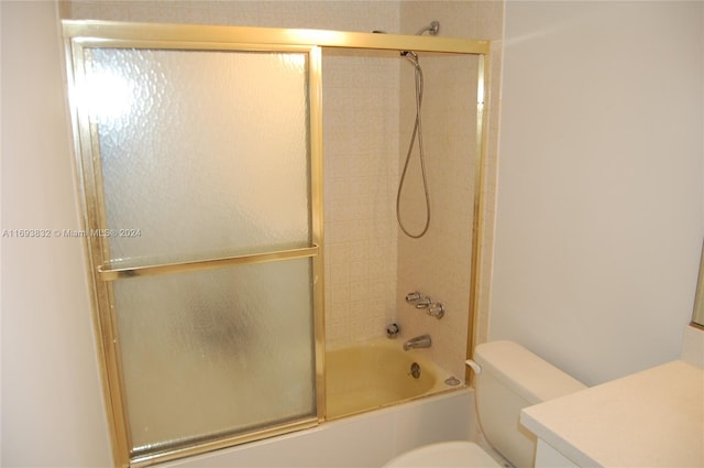 full bathroom featuring vanity, enclosed tub / shower combo, and toilet