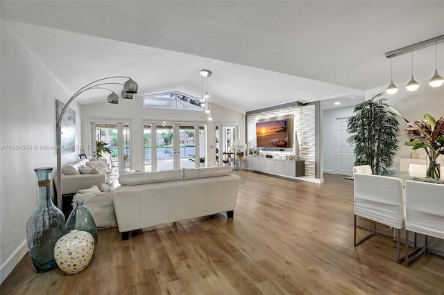 living room featuring french doors, wood-type flooring, and vaulted ceiling