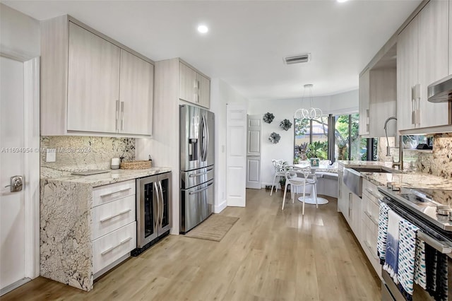 kitchen with beverage cooler, stainless steel appliances, tasteful backsplash, light hardwood / wood-style flooring, and decorative light fixtures