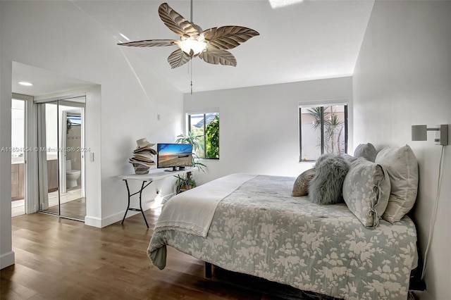 bedroom featuring dark hardwood / wood-style flooring, ceiling fan, lofted ceiling, and connected bathroom