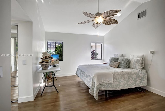 bedroom featuring multiple windows, ceiling fan, hardwood / wood-style floors, and lofted ceiling